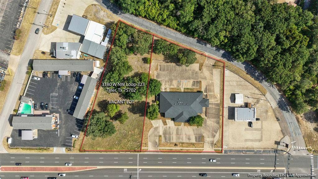 3210 W Northwest Loop 323, Tyler, TX 75702 Property featuring a single-story building with a dark shingle roof, surrounded by extensive paved parking areas LISTED AT $799,000 Opportunity to expand! 3180 W NW LOOP 323 TYLER Adjacent 1.01-acre commercial lot available SEPARATELY for $110,000. Lot is NOT included in the building’s listed price.