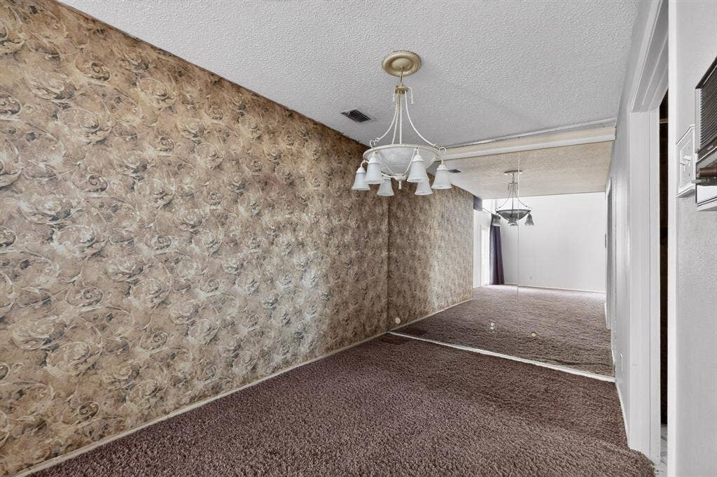 12502 Burninglog Lane, Dallas, TX 75243 Wallpapered wall, carpeted flooring, mirrored wall, and overhead chandelier