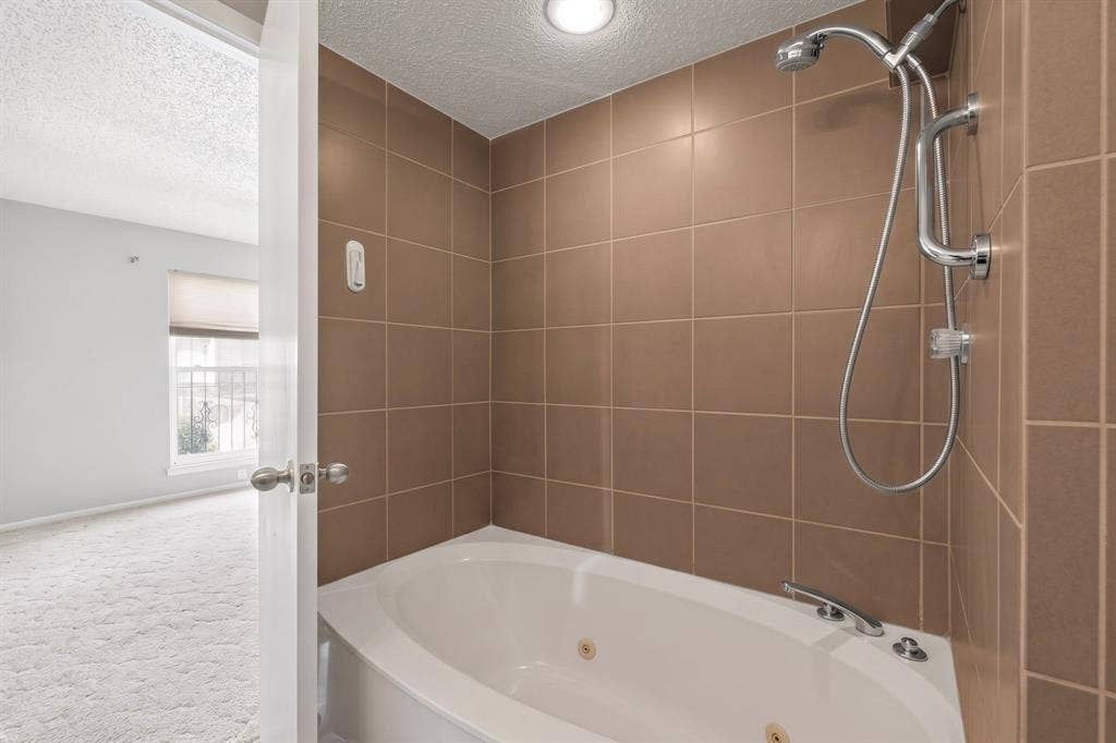12502 Burninglog Lane, Dallas, TX 75243 Built-in jetted tub with chrome fixtures and handheld shower