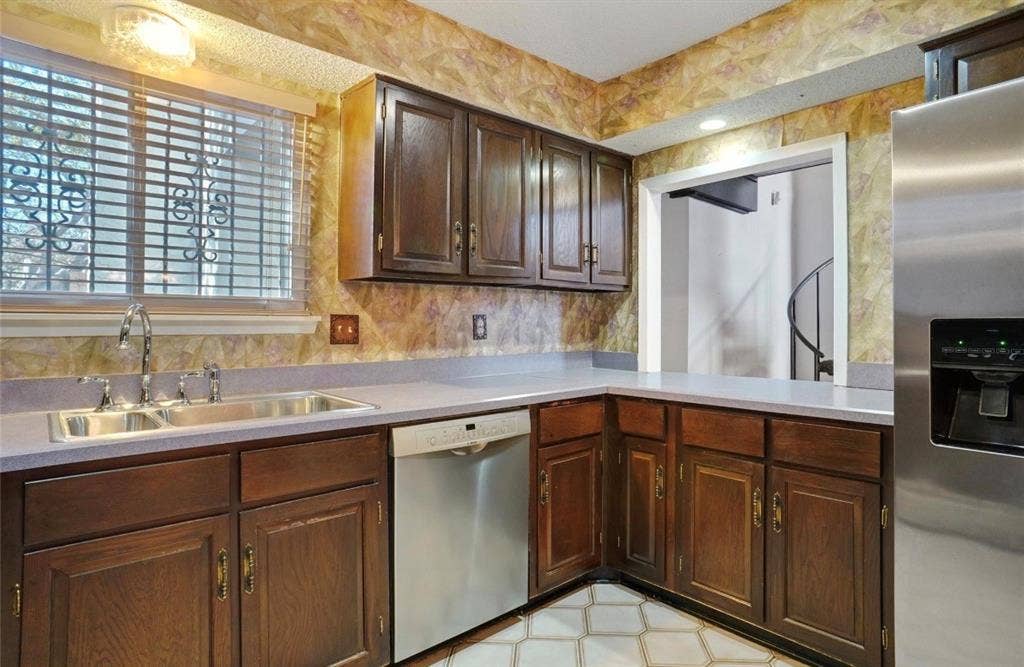 12502 Burninglog Lane, Dallas, TX 75243 Kitchen featuring wood cabinetry, stainless steel dishwasher, stainless steel refrigerator, dual basin sink, and counter space