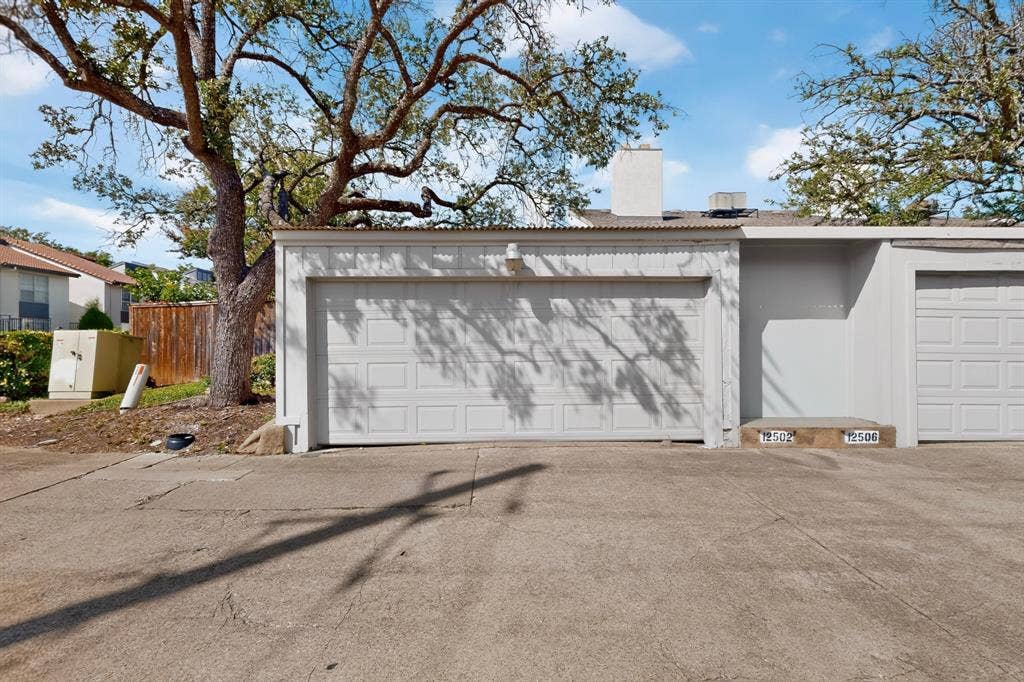 12502 Burninglog Lane, Dallas, TX 75243 White garage door with panel detailing