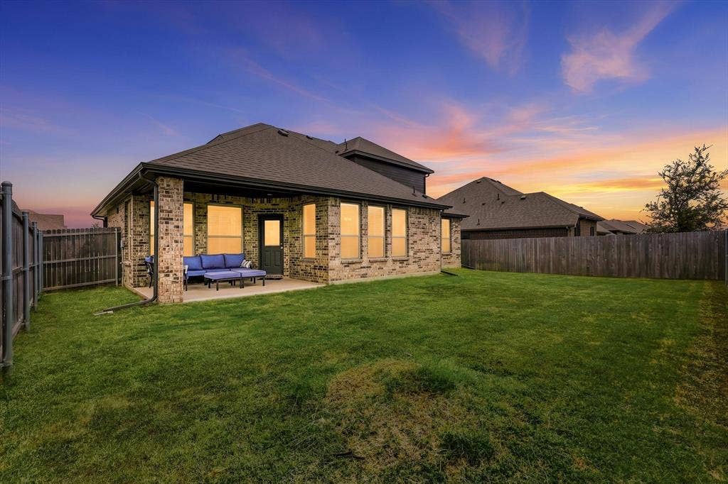 401 Llano Lane, Red Oak, TX 75154 Expansive backyard with a manicured lawn, full privacy fencing, and a concrete patio