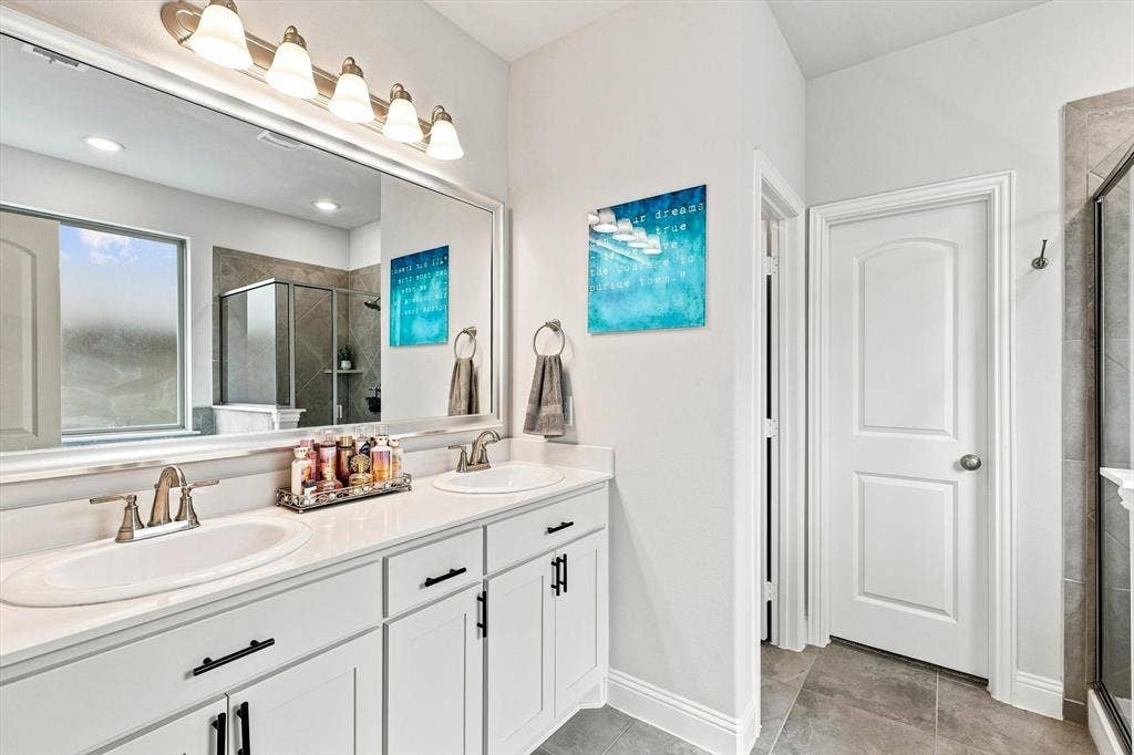 401 Llano Lane, Red Oak, TX 75154 Dual vanity with white cabinetry, polished chrome fixtures, and a large mirror