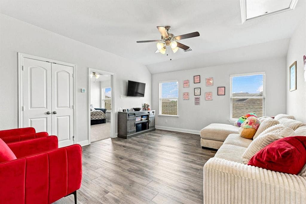 401 Llano Lane, Red Oak, TX 75154 Vaulted ceilings with a ceiling fan, wood-finish flooring, two windows with blinds, and white double doors