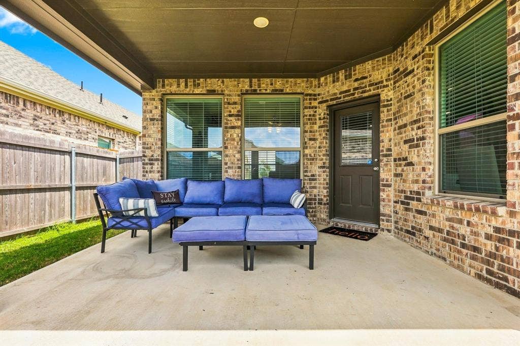 401 Llano Lane, Red Oak, TX 75154 Covered back patio concrete featuring a brick exterior and wood privacy fencing
