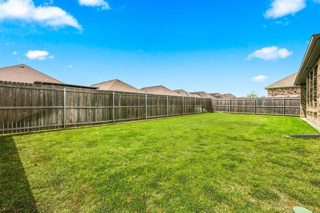 401 Llano Lane, Red Oak, TX 75154 Expansive backyard with a manicured lawn, full privacy fencing, and brick exterior
