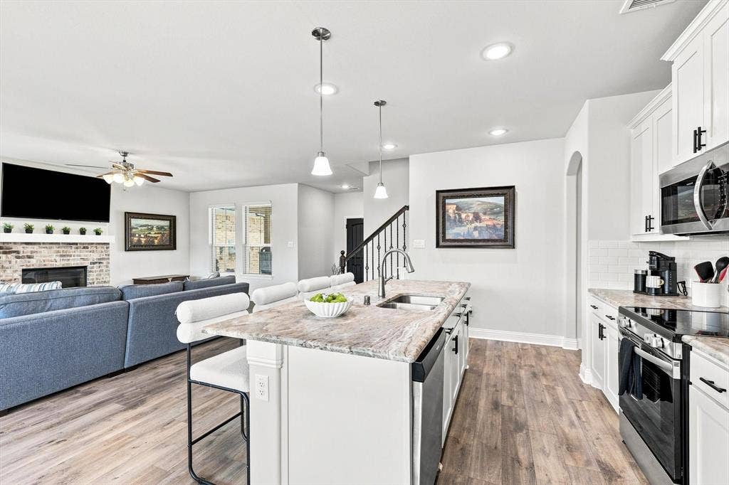 401 Llano Lane, Red Oak, TX 75154 Kitchen with white shaker cabinetry, stainless steel appliances, and a central island with a double basin sink and pendant lighting