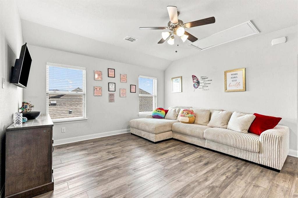 401 Llano Lane, Red Oak, TX 75154 Wood-finish flooring throughout, light-colored walls, multiple windows with blinds, and a ceiling fan with integrated lighting