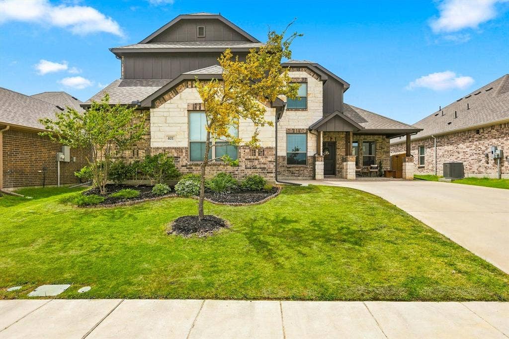 401 Llano Lane, Red Oak, TX 75154 Two-story exterior with brick and stone accents, covered front porch, and an attached two-car garage