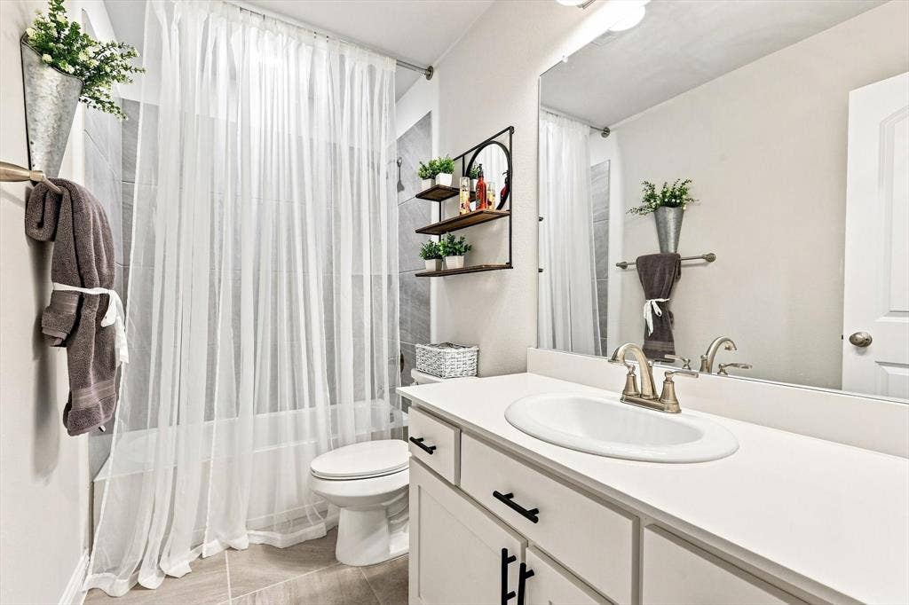 401 Llano Lane, Red Oak, TX 75154 Vanity with an integrated sink, brushed nickel faucet, and a large wall-mounted mirror