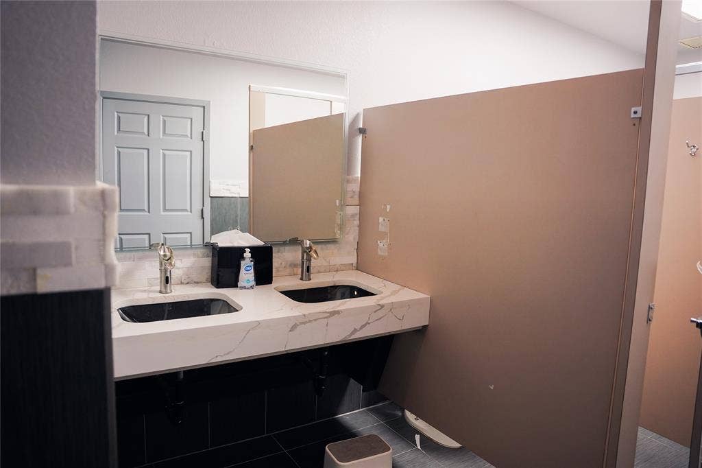2705 Virginia Parkway, #SLE, McKinney, TX 75071 Dual black vessel sinks with gold-finish faucets set in a white marble-look countertop