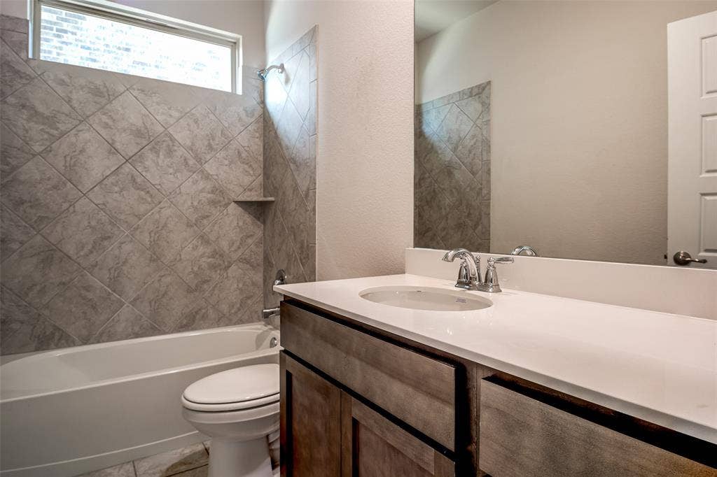 2721 Franklin Drive, Celina, TX 75009 Bathroom featuring a wood-finish vanity with a white countertop, an undermount sink, and a chrome faucet