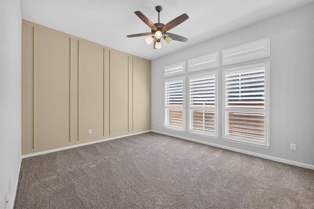 5308 Tupper Avenue, Fate, TX 75087 Spacious bedroom with neutral carpet flooring, ceiling fan with integrated lighting, and expansive wall of built-in cabinetry featuring vertical paneling