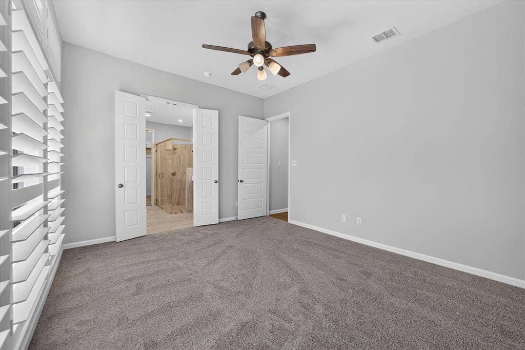 5308 Tupper Avenue, Fate, TX 75087 Carpeted room with a ceiling fan, white paneled doors, and plantation shutters