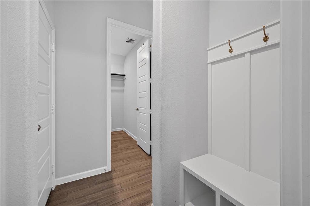 5308 Tupper Avenue, Fate, TX 75087 Built-in storage bench with coat hooks, wood-finish flooring, and white paneled doors