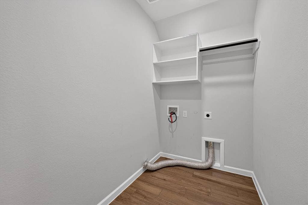 5308 Tupper Avenue, Fate, TX 75087 Laundry area featuring wood-finish flooring, white built-in shelving, and a garment rod