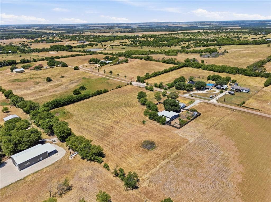 TBD Lot 1 Bluebonnett Lane, Lorena, TX 76655 Expansive acreage with multiple structures, including a primary residence, detached outbuilding, and a separate structure with a pool