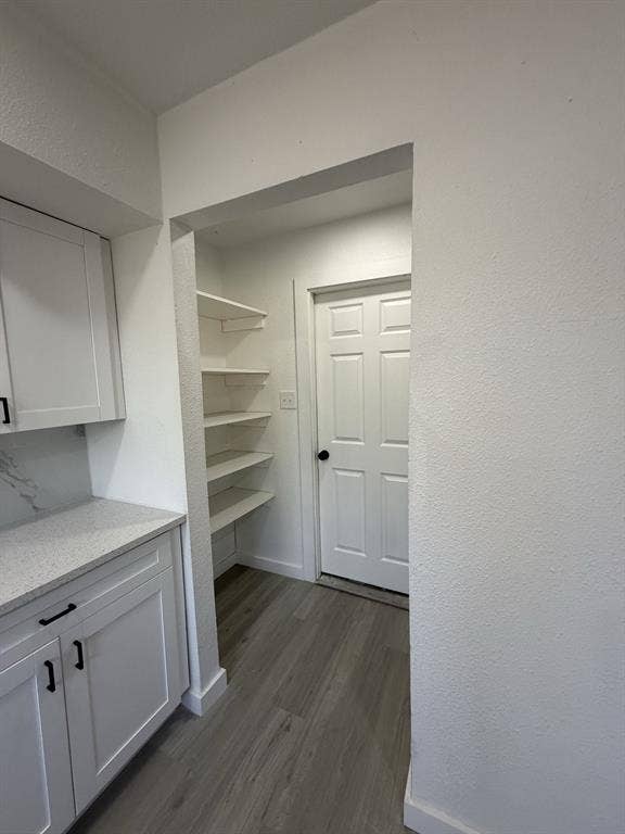 806 S Atkerson Lane, Euless, TX 76040 Utility room with built-in shelving, white cabinetry, and wood-finish flooring