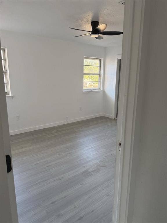 806 S Atkerson Lane, Euless, TX 76040 Light-toned wood-finish flooring, white walls, two windows, and a ceiling fan with integrated lighting