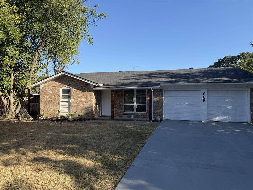 806 S Atkerson Lane, Euless, TX 76040 Brick exterior with a gray asphalt shingle roof, attached two-car garage, and a concrete driveway