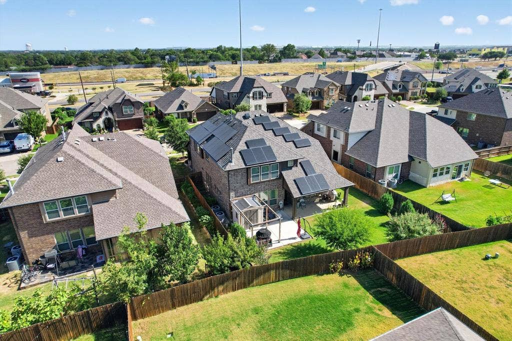 316 Jernigan Drive, Euless, TX 76040 Brick-clad residence with a shingled roof, featuring multiple solar panels and a covered patio
