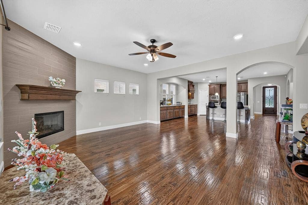 316 Jernigan Drive, Euless, TX 76040 Open-concept living space featuring wood-finish flooring, a tiled fireplace with wood mantel, recessed lighting, and a ceiling fan