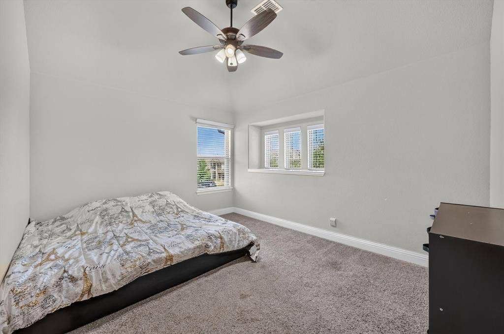 316 Jernigan Drive, Euless, TX 76040 Vaulted ceiling with an attached ceiling fan, carpeted flooring, and multiple windows with blinds