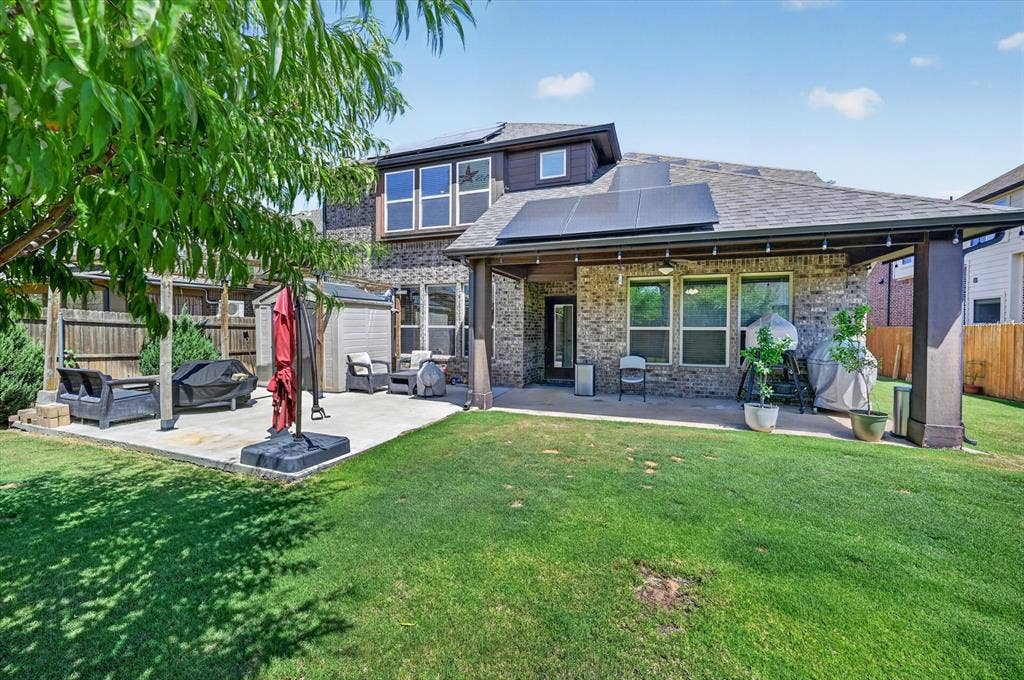 316 Jernigan Drive, Euless, TX 76040 Expansive backyard featuring a covered patio, additional concrete patio space, wood fence, and solar panels