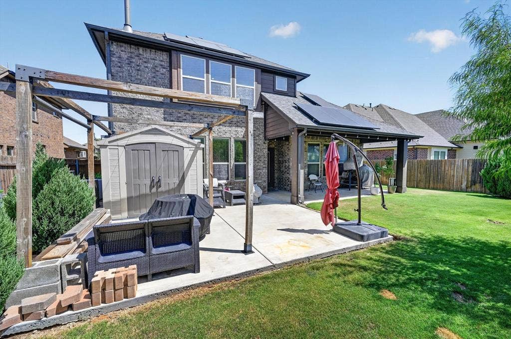 316 Jernigan Drive, Euless, TX 76040 Expansive backyard with a concrete patio, wood pergola frame, and a storage shed