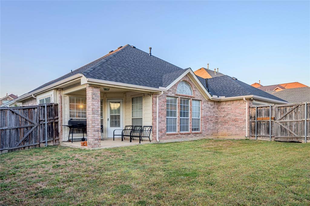 Brick exterior with a covered patio, gabled roofline, and arched window