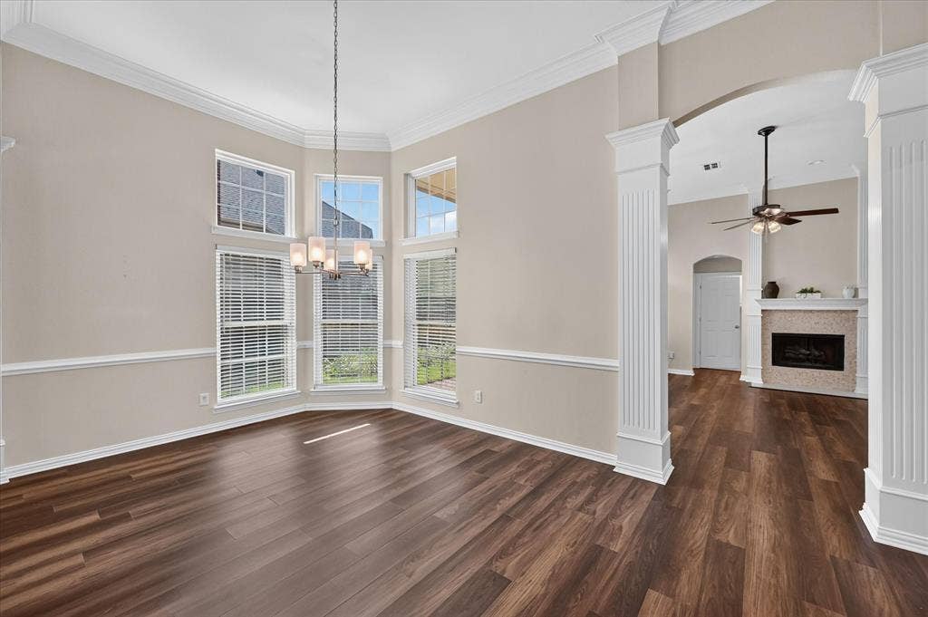 10307 Perkins Drive, Irving, TX 75063 Bay window with multiple panes, wood-finish flooring, decorative wall trim, and an elegant chandelier