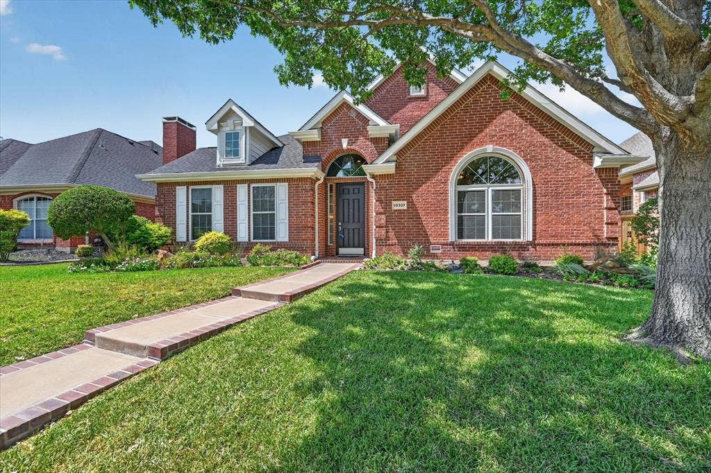 10307 Perkins Drive, Irving, TX 75063 Brick exterior with white window shutters and an arched transom window