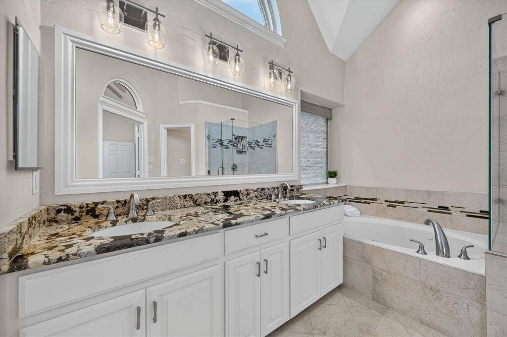 10307 Perkins Drive, Irving, TX 75063 Dual vanity with stone countertop, undermount sinks, and white cabinetry