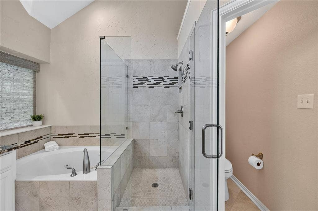 10307 Perkins Drive, Irving, TX 75063 Walk-in shower with clear glass enclosure and tile surround