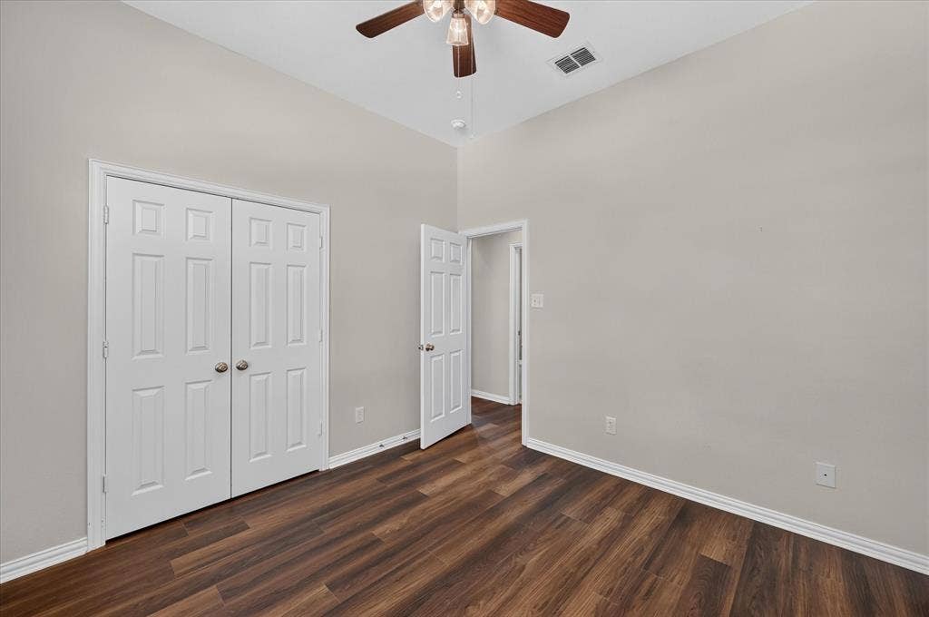 10307 Perkins Drive, Irving, TX 75063 Vaulted ceiling, wood-finish flooring, ceiling fan with integrated lighting, paneled bifold doors, and a paneled entry door