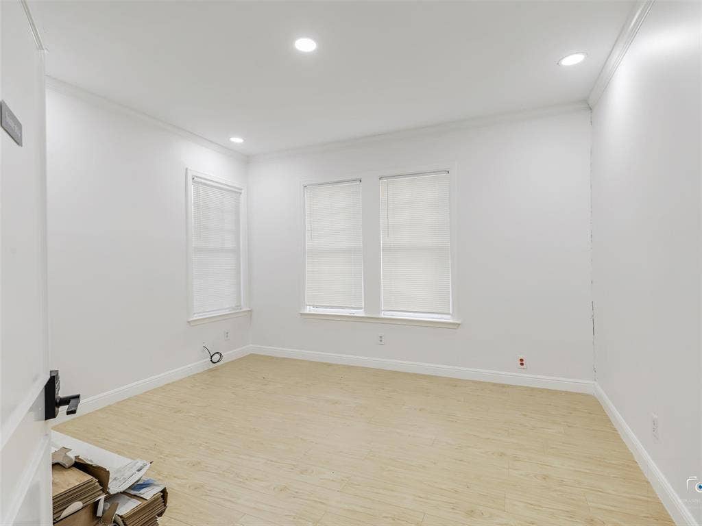 4310 Gaston Avenue, #103, Dallas, TX 75246 Recessed ceiling lighting, crown molding, two windows with blinds, wood-finish flooring, and a white door with a black handle