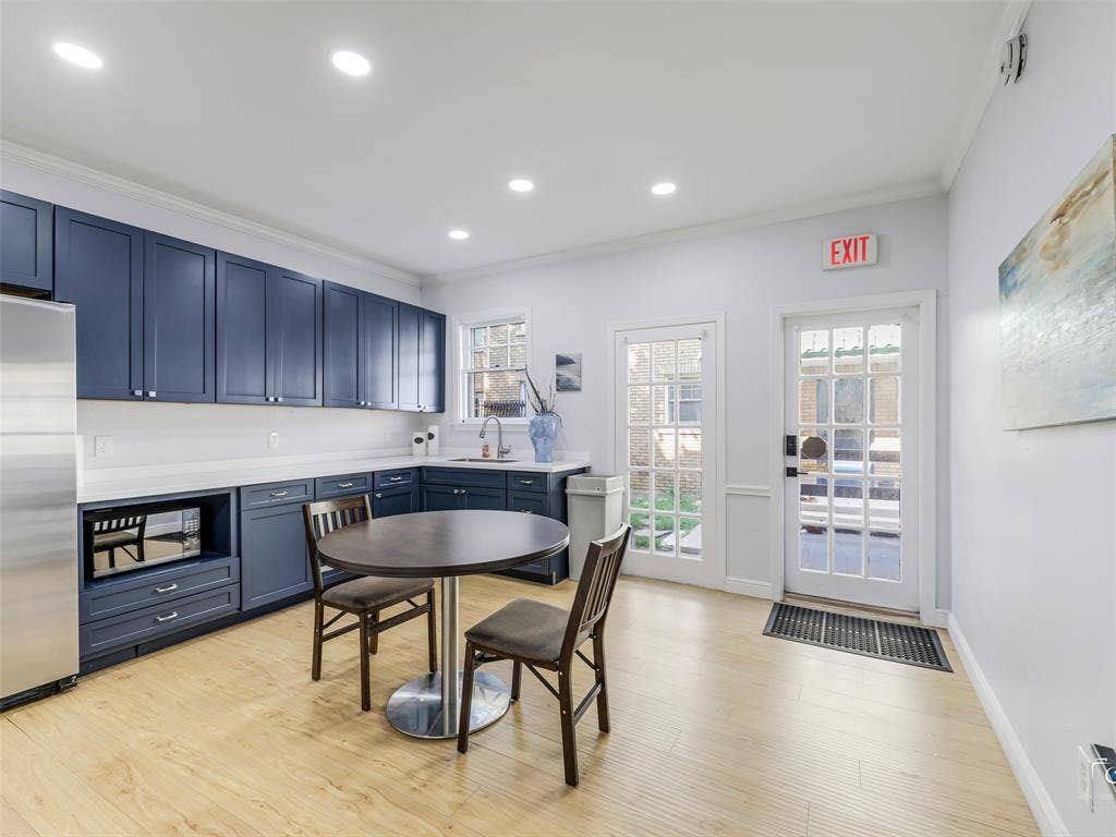 4310 Gaston Avenue, #103, Dallas, TX 75246 Kitchenette featuring wood-finish flooring, recessed lighting, blue cabinetry, white countertops, and dual glass-paned doors