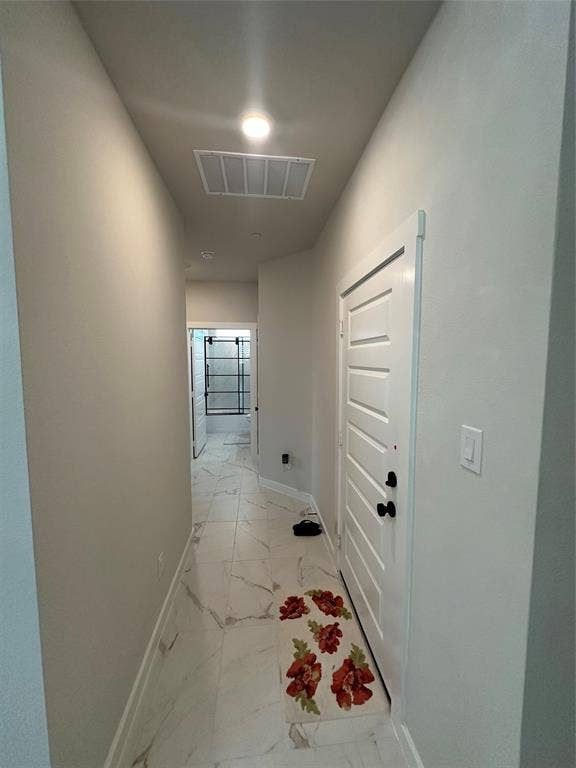 Hallway with white tile flooring and a white paneled door