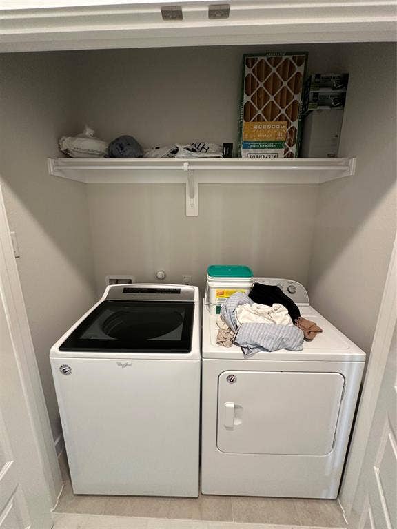 Laundry area with a white top-load washer and white dryer
