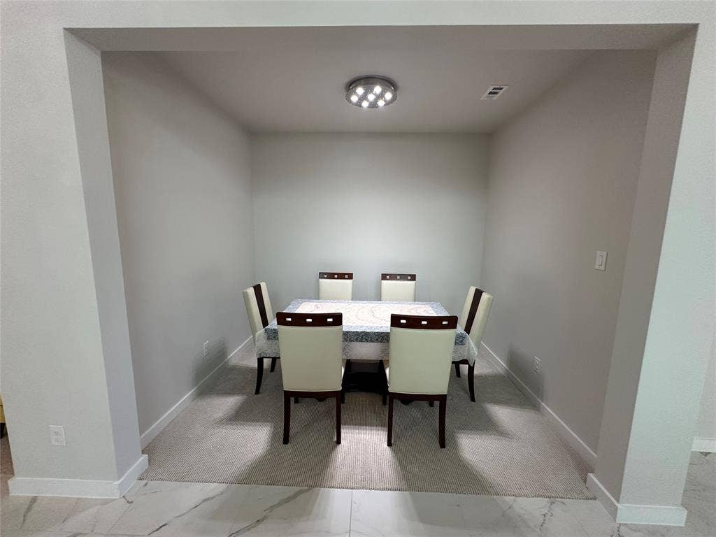 Recessed dining area with carpeted flooring and a flush-mount ceiling light fixture