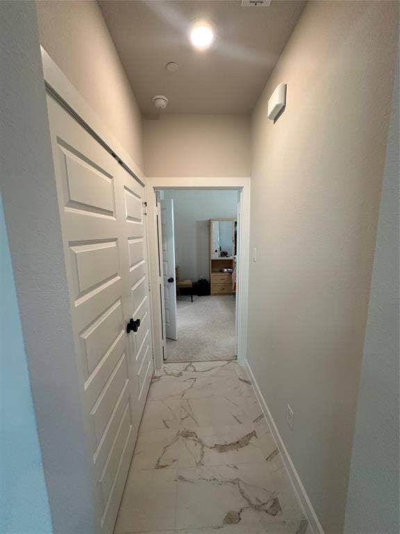 Hallway with patterned tile flooring, white paneled doors, and recessed lighting