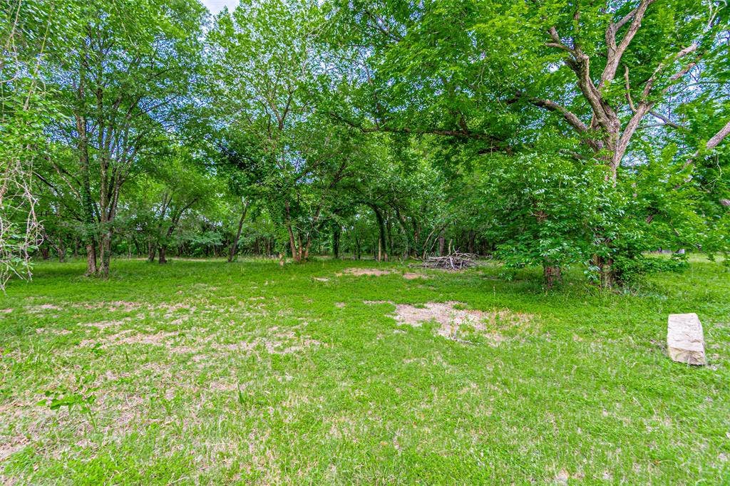 3018 River View Court, Granbury, TX 76048 Expansive green space featuring a large grassy area and mature trees