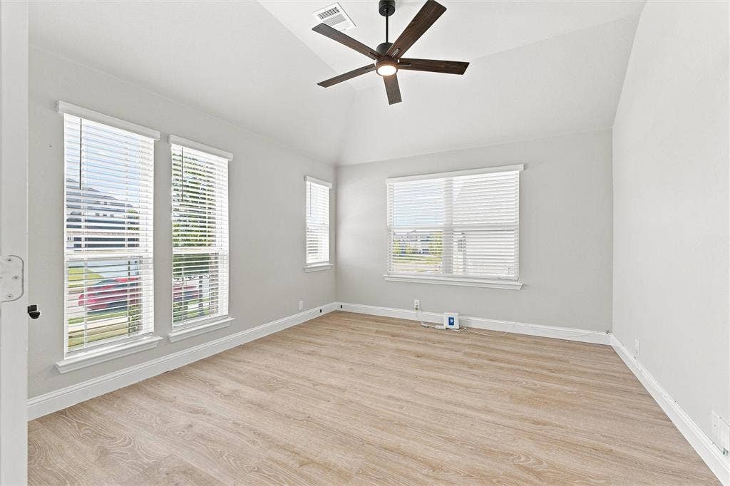 5225 Rowlan Row, Midlothian, TX 76065 Vaulted ceiling with a contemporary ceiling fan, multiple windows with blinds, and wood-finish flooring