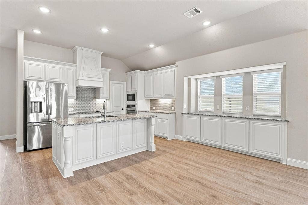 5225 Rowlan Row, Midlothian, TX 76065 Gourmet kitchen with white cabinetry, granite countertops, stainless steel appliances, and wood-finish flooring