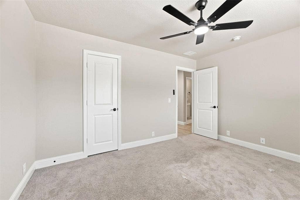 5225 Rowlan Row, Midlothian, TX 76065 Soft gray wall paint, light-colored carpeting, white trim, and a ceiling fan with integrated lighting