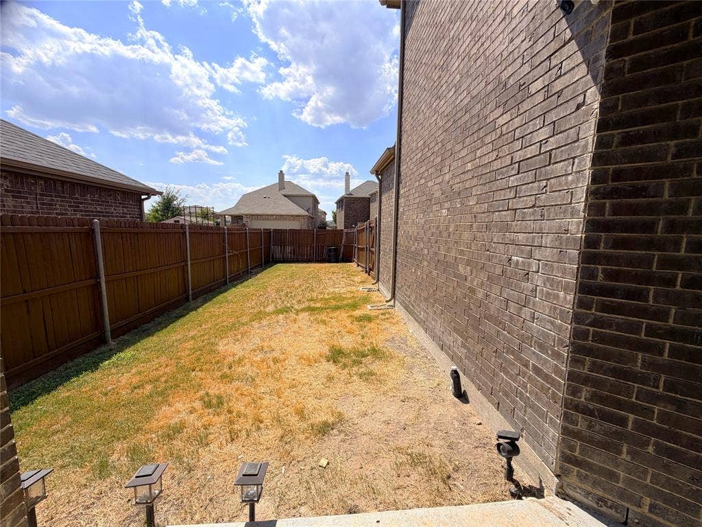 4103 Portrush Drive, Heartland, TX 75126 Brick exterior, wood privacy fence, and concrete patio