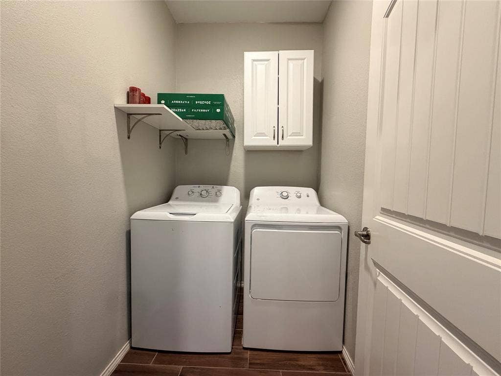 4103 Portrush Drive, Heartland, TX 75126 Laundry area featuring wood-finish flooring, white wall-mounted cabinetry, and corner shelving