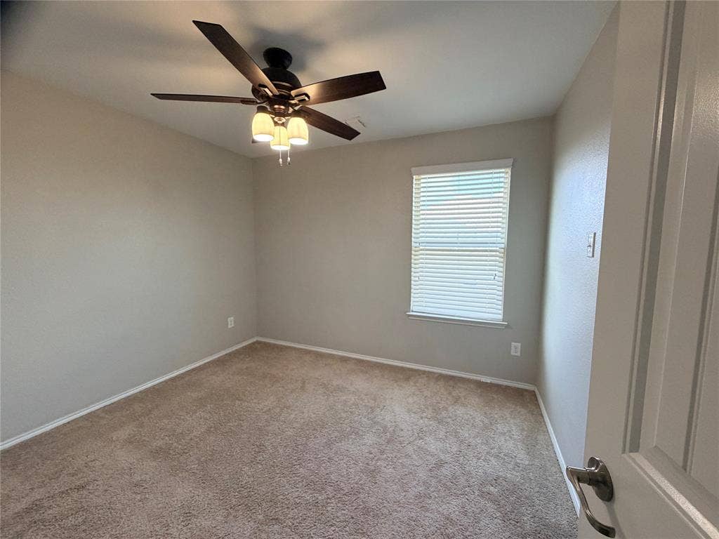 4103 Portrush Drive, Heartland, TX 75126 Neutral tone wall paint, textured carpeting, window with blinds, ceiling fan with integrated lighting