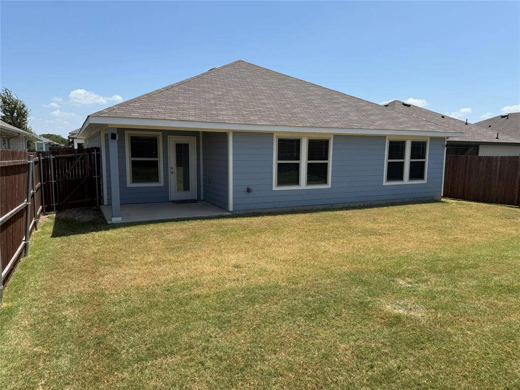 6534 Whitecap Drive, Princeton, TX 75407 Rear exterior with blue siding, a covered patio, and a privacy fence