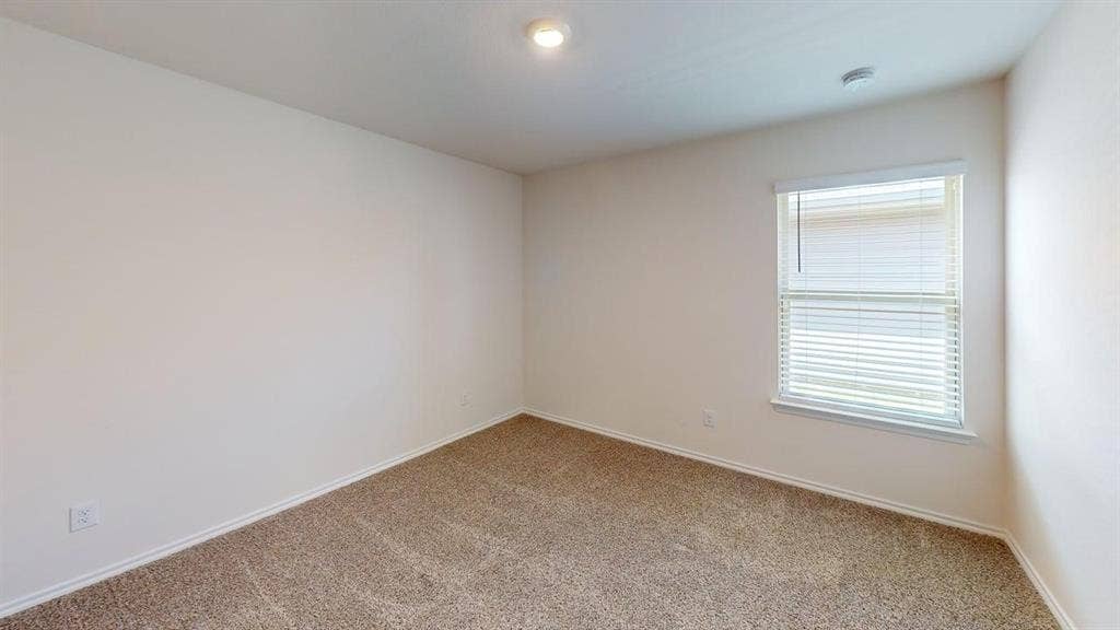 6534 Whitecap Drive, Princeton, TX 75407 Neutral wall paint, textured carpeting, recessed ceiling lighting, and a single window with blinds